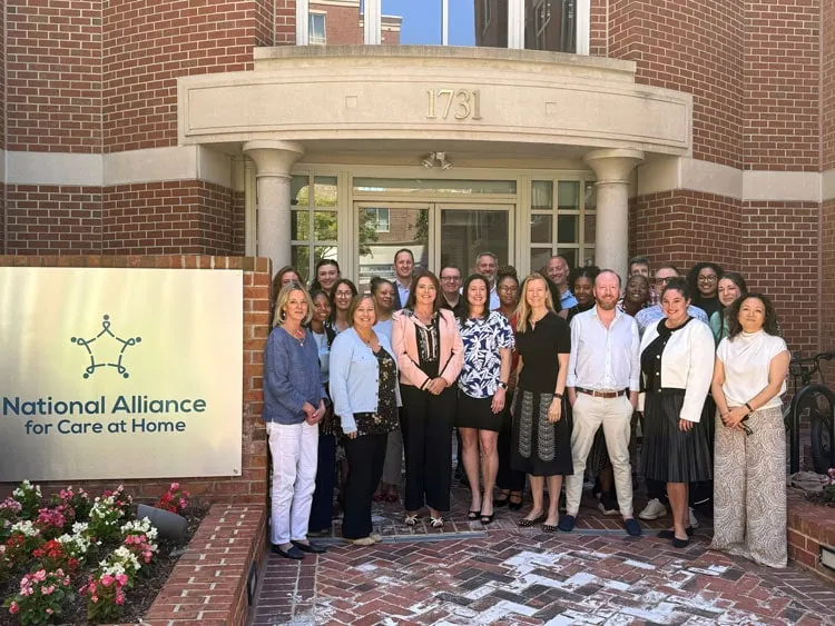 Group of diverse professionals and caregivers outside the National Alliance for Care at Home buildin.