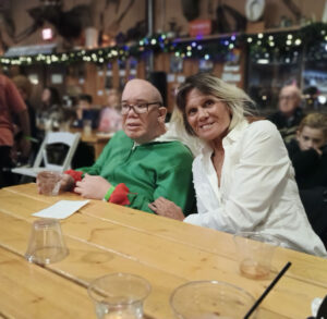 Caregiver and loved one sharing a joyful moment at a restaurant.