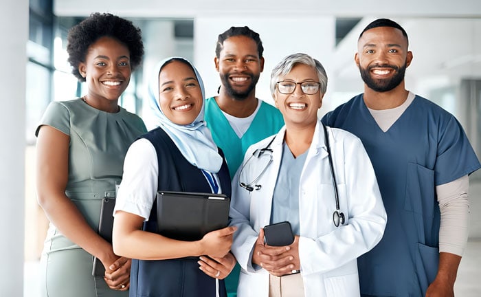 Diverse healthcare professionals smiling together in a modern medical facility.