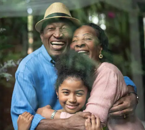 Happy multigenerational family embracing outdoors, promoting caregiving programs.