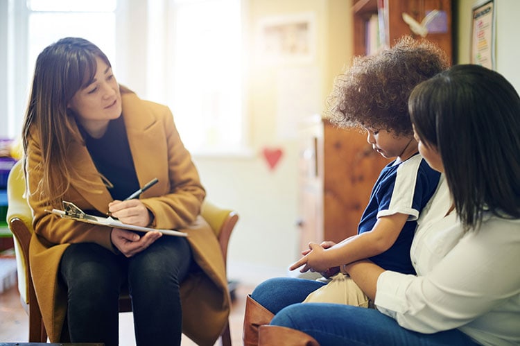 Caregiver and counselor discussing support strategies with children.